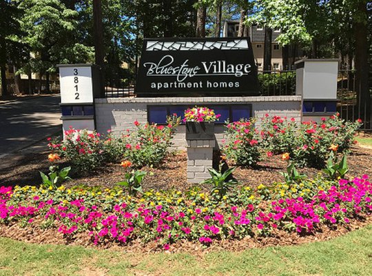 Bluestone village main entrance sign with flowers around it